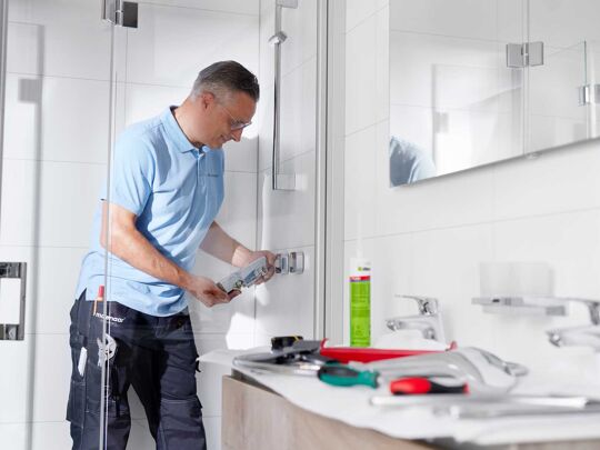 Monteur aan het werk in basic badkamer met gereedschap