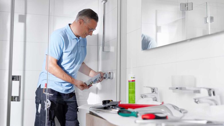 Monteur aan het werk in basic badkamer met gereedschap