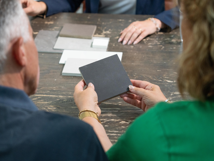 Thuisadviseur tijdens thuisadviesgesprek laat kleurstalen zien