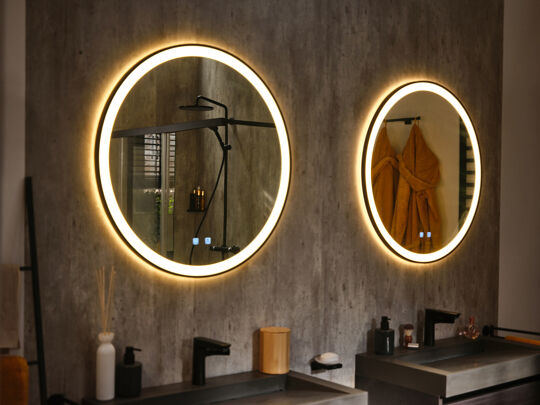 Industriële badkamer ronde verlichte spiegels en badjas in spiegel