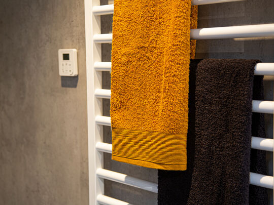Witte radiator okergele en bruine handdoek