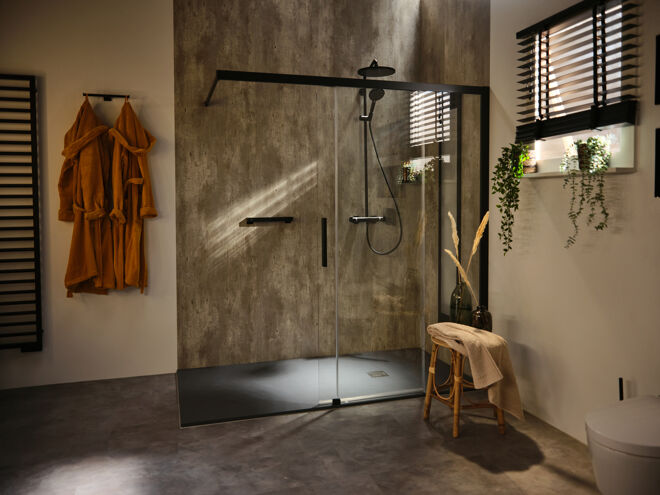 Industriële badkamer met zwarte omlijsting en douchegarnituur en houten krukje