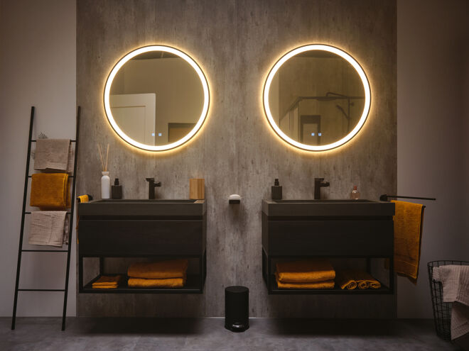 2 Industriële badkamermeubels met ronde spiegels inclusief verlichting en okergele handdoeken