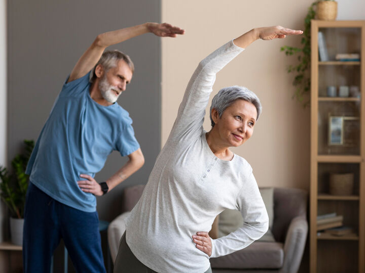 Senioren koppel samen staand yoga sidestretch 